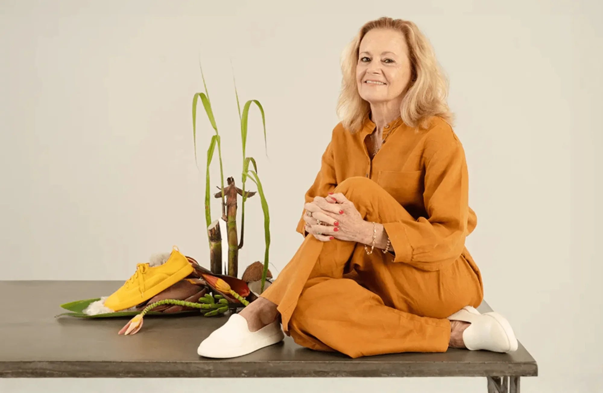 Ms Sue sitting on table wearing juntos off white slip-on