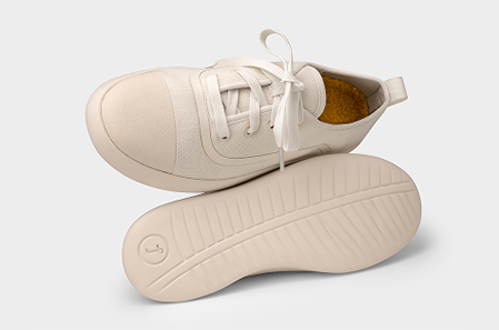Pair of beige sneakers on a light gray background