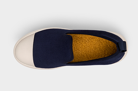 Navy slip-on shoe with beige sole on a light gray background