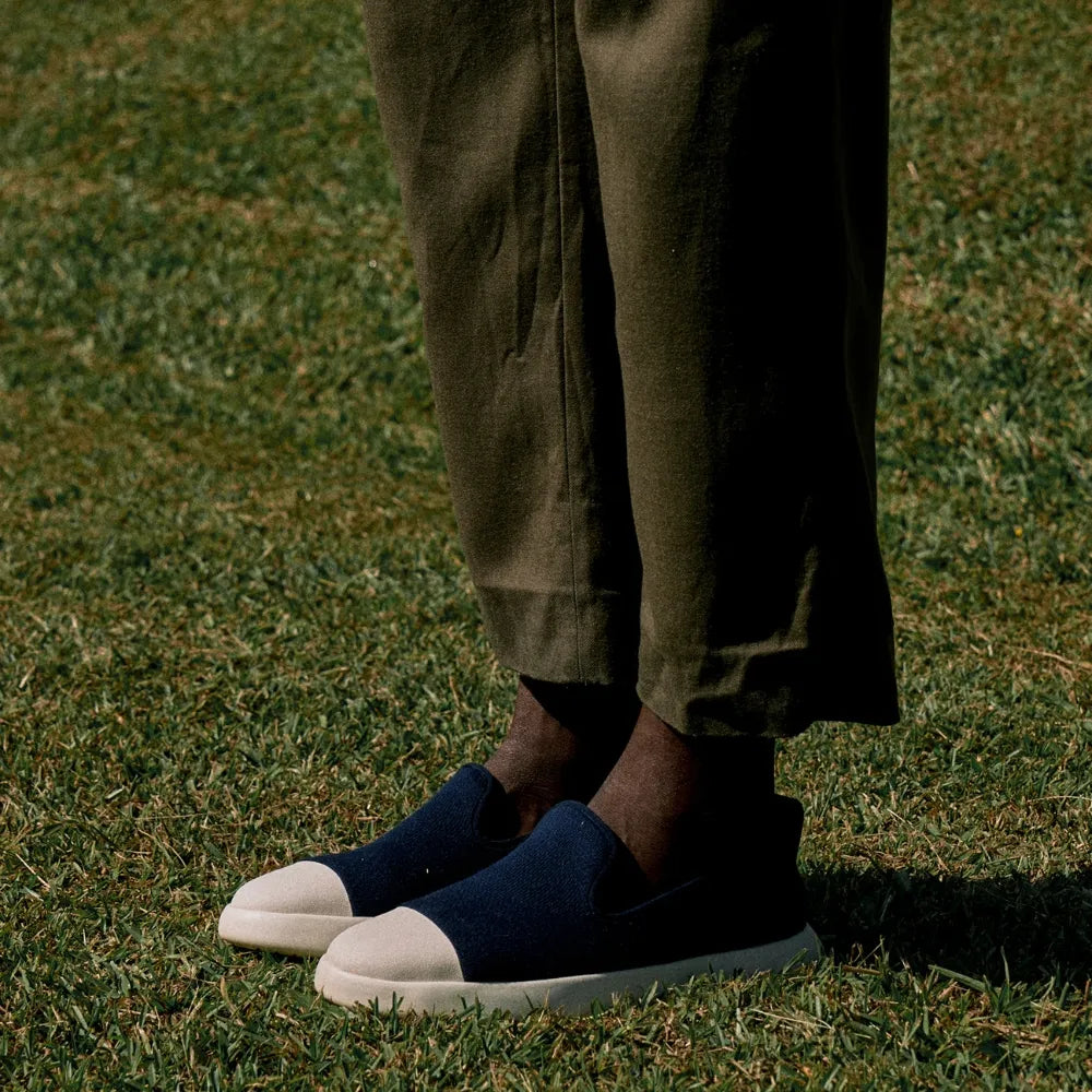 Man standing on grass wearing Juntos Navy Blue Slip-on