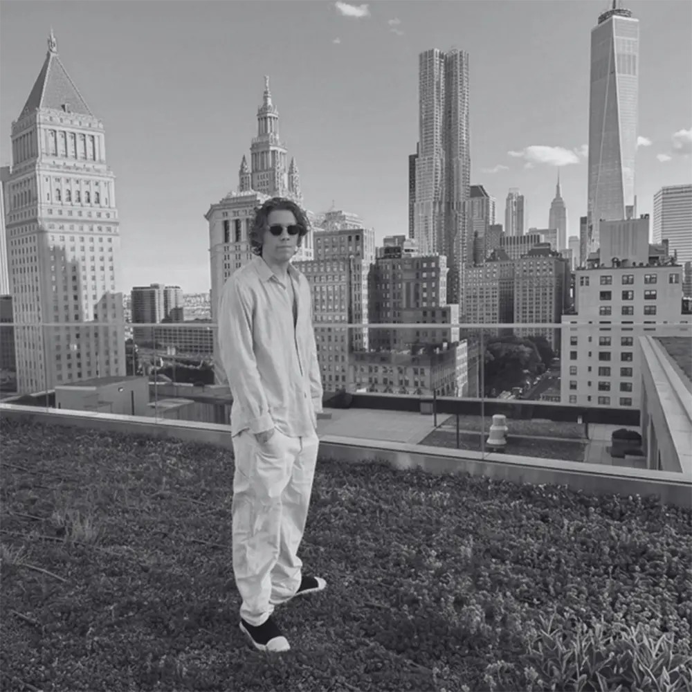 Person standing on a rooftop with a city skyline in the background